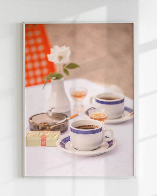 Framed artwork of a Jugokeramika coffee cup set with a flower and Filter 57 on a white wall.