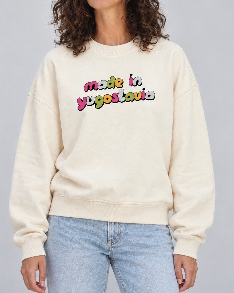 Women's cream oversized crewneck sweatshirt with colourful Made in Yugoslavia lettering, worn with jeans