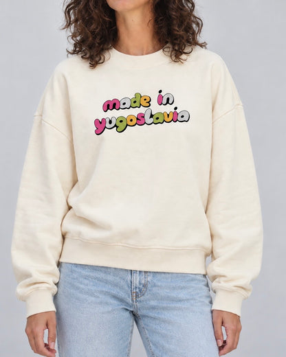 Women's cream oversized crewneck sweatshirt with colourful Made in Yugoslavia lettering, worn with jeans
