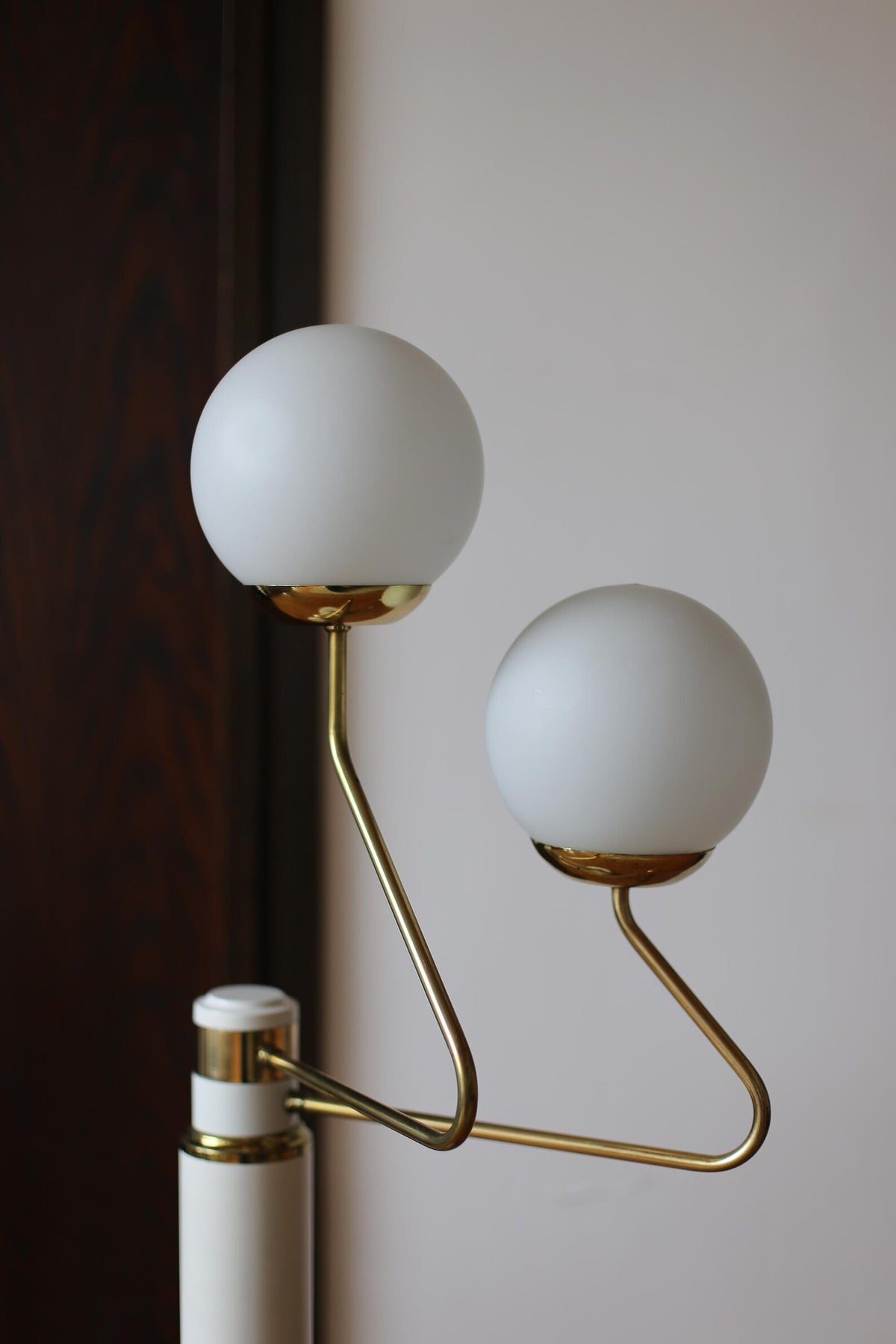 Close-up of the two opaline glass globes and curved brass-plated arms