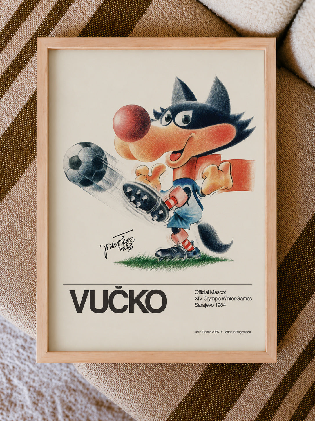 Framed poster of Vucko with a soccer ball on a striped background.